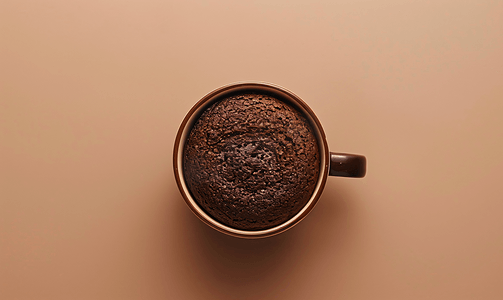 咖啡杯与巧克力蛋糕顶视图孤立在浅棕色