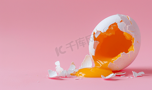 破裂鸡蛋摄影照片_这是粉红色背景上破裂的鸡蛋的照片