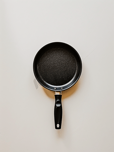 烹饪插图摄影照片_白色背景上的黑色煎锅