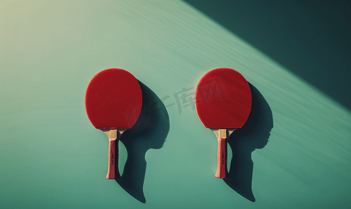 乒乓球运动摄影照片_乒乓球桌上的两个红色网球拍