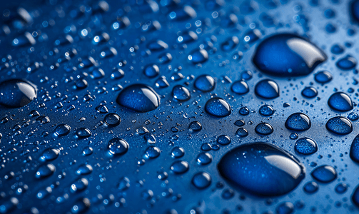 自然水滴摄影照片_蓝色金属表面上的露水滴