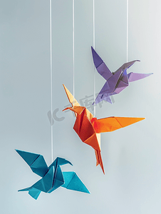 折纸风海报摄影照片_绑在绳子上的彩色纸折纸鸟