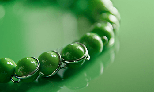 珠宝时尚背景摄影照片_绿色丝球和金属环制成的项链