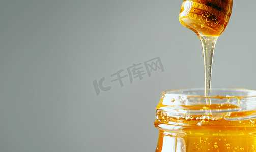 蜂蜜从木棍流到玻璃罐里