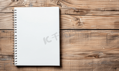 手抄报模板边框摄影照片_在木背景的空白的白色螺旋笔记本