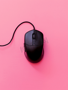 粉红色背景上黑色游戏光电鼠标的特写