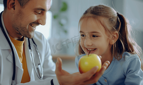 生气的小男生摄影照片_保健 儿童医学男医生给个微笑的小女孩苹果