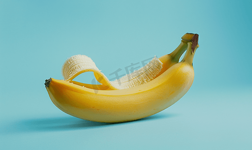 黄色背景卡通摄影照片_躺着去皮的黄色香蕉隔离