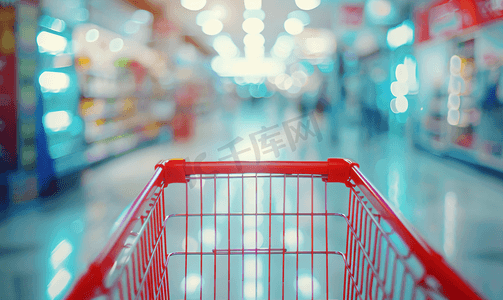 家电卖场开业摄影照片_超市过道模糊离焦背景与空红色购物车