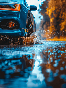 雨水花摄影照片_蓝色汽车穿越水坑日光特写时溅起水花