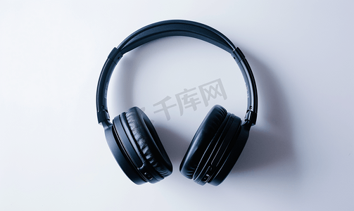 耳机黑色摄影照片_白色背景上隔离的无线黑色耳机的近距离视图