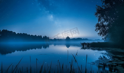 蓝色宇宙星空摄影照片_夏季雾气弥漫的夜晚星空下的小湖