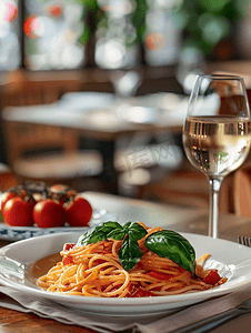 一杯酒卡通摄影照片_餐厅桌上的意大利面食和一杯酒