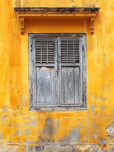 带铁门和百叶窗的旧黄墙