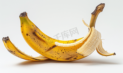 黄色背景卡通摄影照片_半成熟的香蕉在果皮上孤立在白色