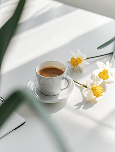 黄色页面摄影照片_白桌上放着一杯咖啡和水仙花的记事本鼓舞人心的工作场所