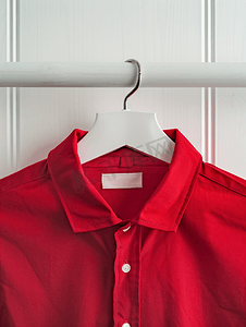 火字体样式摄影照片_红色棉衬衫上的白色洗衣护理洗涤说明衣服标签