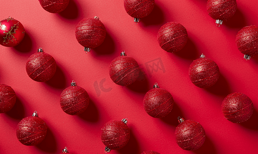 红色背景顶视图上的圣诞球小玩意图案最小平铺