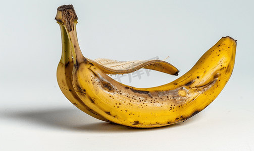 卡通叶子绿色摄影照片_半成熟的香蕉在果皮上孤立在白色