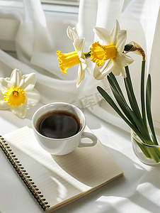 白桌上放着一杯咖啡和水仙花的记事本鼓舞人心的工作场所