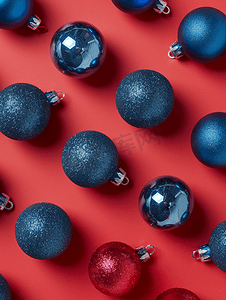 圣诞节图案摄影照片_红色背景顶视图上的蓝色圣诞球小玩意图案最小平铺