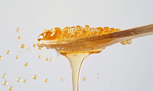 透明的蜂蜜从隔离的木棍上流下来