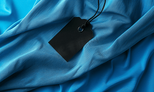 蓝色针织聚酯运动衬衫背景上的黑色空白洗衣护理衣服标签