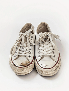 跑步运动的人摄影照片_白色背景中突显的一双破旧的运动鞋