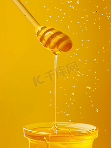 天然蜂蜜从黄色背景的蜂蜜桶中流下