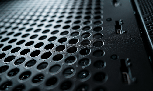 台式饭团摄影照片_黑色台式电脑机箱灰尘覆盖的电源网格