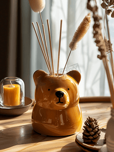 火焰的背景设计摄影照片_木头上的陶瓷纪念品熊头和家用香水扩散器