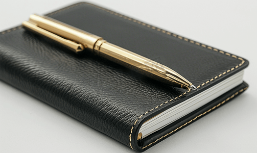 优质黑色皮革笔记本配有金色笔白色背景上孤立