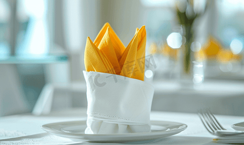 白桌上的白色瓷餐巾中的黄色和白色餐巾特写