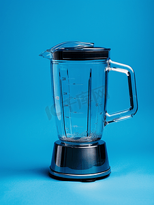 插图水果摄影照片_蓝色背景中带空杯的电动搅拌机