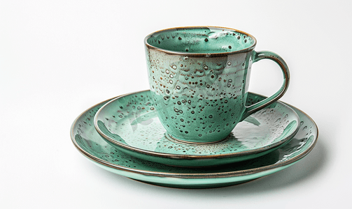 白色背景中的一组绿色陶瓷盘子和咖啡杯