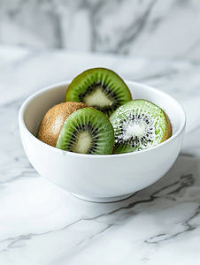 大理石厨房桌子上的白色碗里放着猕猴桃新鲜多汁的热带水果