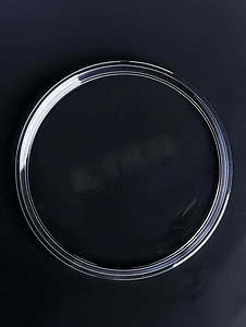 黑色标签摄影照片_黑色背景上隔离的透明粘胶圆形塑料贴纸标签