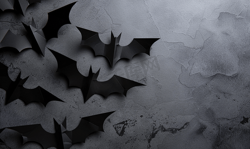 动物蝙蝠摄影照片_灰色背景上的万圣节概念黑纸蝙蝠复制空间