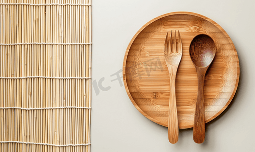 桌子上的空盘子摄影照片_竹制底板上的天然木质盘子、勺子和叉子