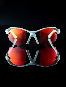 酷酷眼镜摄影照片_黑色背景上带有红色镜面镜片和白色镜框的运动眼镜