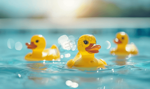 羽毛红色摄影照片_黄色塑料鸭子在水里游泳