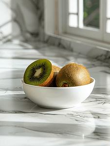 水果厨房背景摄影照片_大理石厨房桌子上的白色碗里放着猕猴桃新鲜多汁的热带水果