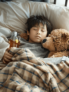 棕熊摄影照片_亚洲男孩患流感棕熊躺在病床上治