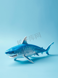 蓝色水下世界摄影照片_蓝色背景的鲨鱼玩具有可用空间