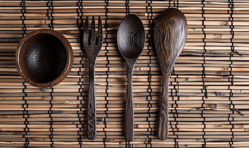 亚洲竹背上的深色木勺叉和空杯