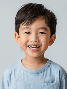 蛀牙虫卡通摄影照片_亚洲男孩微笑着蛀牙