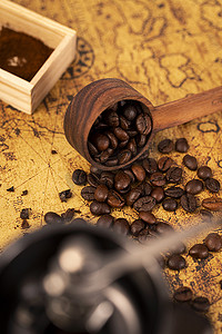 北宋地图摄影照片_勺子里的咖啡豆散落在旧地图上