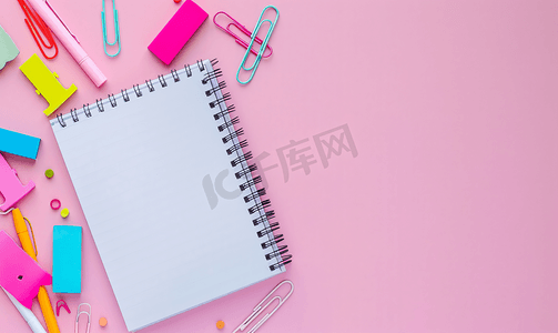 粉红色信纸摄影照片_学校螺旋笔记本上贴有粉红色背景贴纸位于纸张顶部