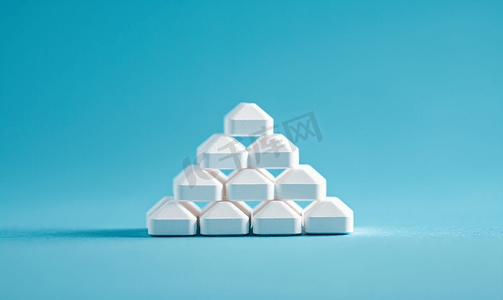 蓝色背景中金字塔形状的白色药片