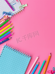 的铅笔摄影照片_粉红色背景的学校用品文具钢笔铅笔记事本平躺